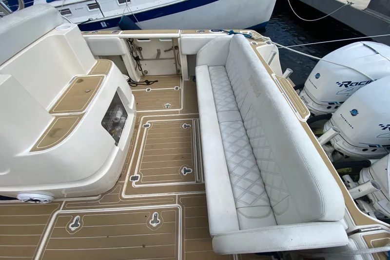 Slide: The Image of 2006 Intrepid 377 boat interior with cushioned seating and twin outboard motors. - 21