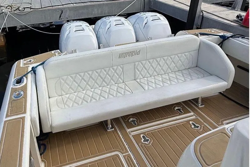 Slide: The Image of 2006 Intrepid 377 boat with white seating and triple outboard engines. - 23