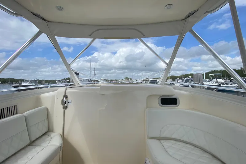 Slide: The Image of Interior view of a 2006 Intrepid 377 boat with white seating and marina backdrop. - 25
