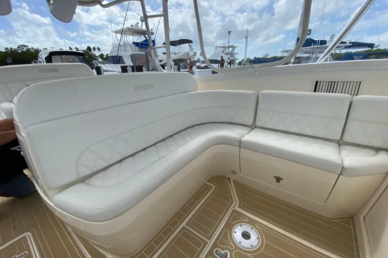Slide: The Image of Luxurious white seating on a 2006 Intrepid 377 boat, docked with other vessels. - 27