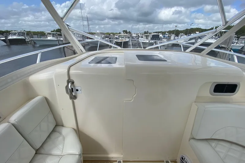 Slide: The Image of 2006 Intrepid 377 boat interior with seating, docked at marina under cloudy sky. - 29