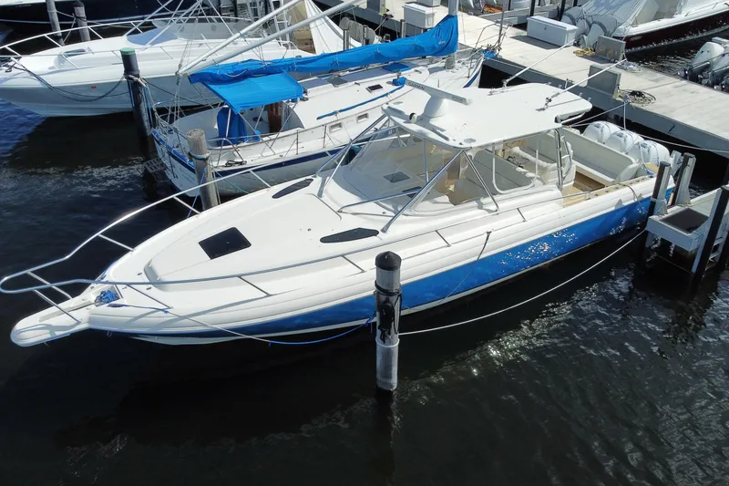 Slide: The Image of 2006 Intrepid 377 boat docked at marina, featuring sleek white and blue design. - 3