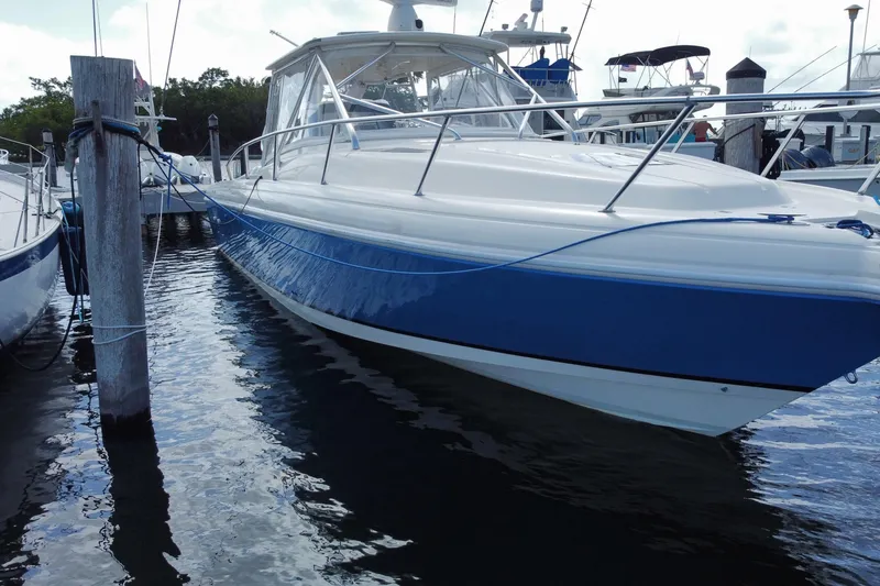 Slide: The Image of 2006 Intrepid 377 boat docked, featuring sleek blue and white design. - 4