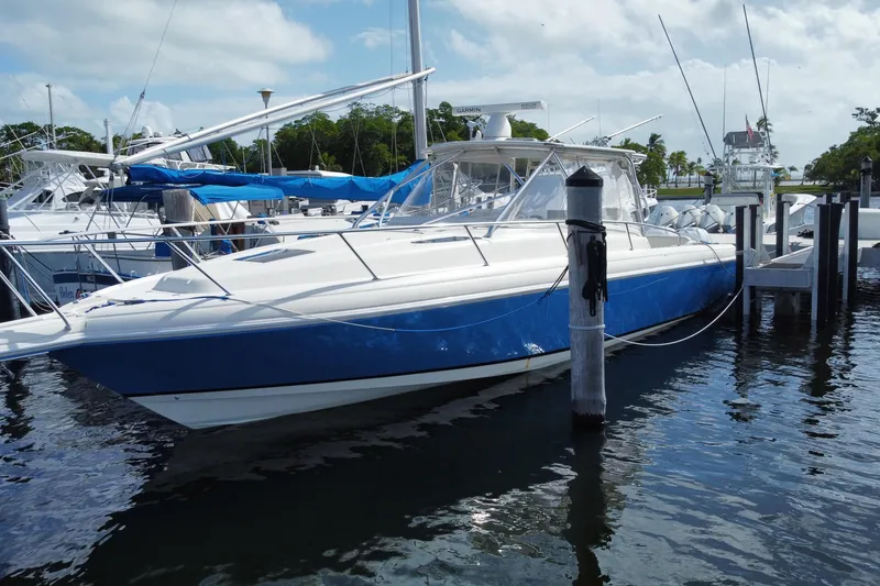 Slide: The Image of 2006 Intrepid 377 boat docked in marina, featuring sleek blue and white design. - 5