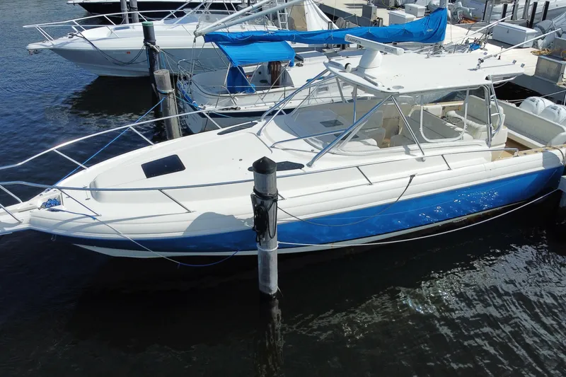 Slide: The Image of 2006 Intrepid 377 boat docked in marina, featuring sleek white and blue design. - 7