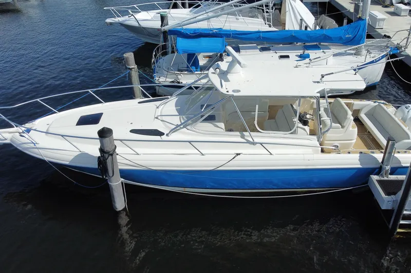 Slide: The Image of 2006 Intrepid 377 boat docked, featuring sleek design and blue hull. - 8