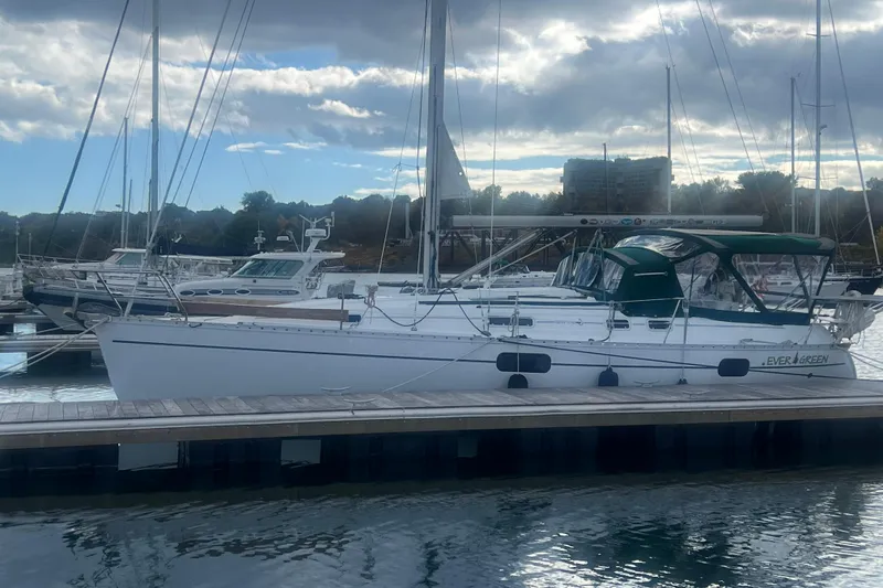 The Image of 1994 Beneteau Oceanis 351 sailboat docked at marina under cloudy sky. - 0