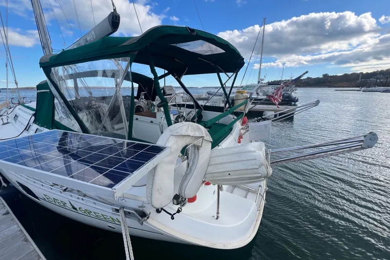 Slide: The Image of 1994 Beneteau Oceanis 351 sailboat with solar panels docked at marina. - 2
