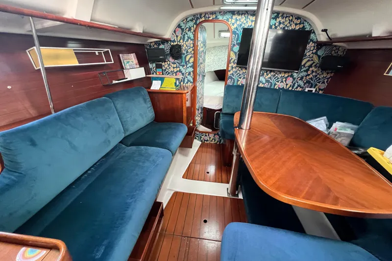 Slide: The Image of Interior of 1994 Beneteau Oceanis 351 sailboat with blue seating and wooden table. - 21