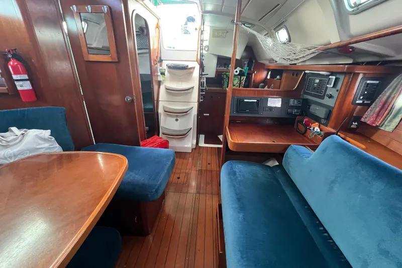 Slide: The Image of Interior of 1994 Beneteau Oceanis 351 sailboat with wooden furnishings and blue seating. - 22