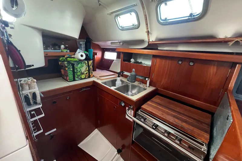 Slide: The Image of Interior of 1994 Beneteau Oceanis 351 sailboat kitchen with wooden cabinetry and appliances. - 25
