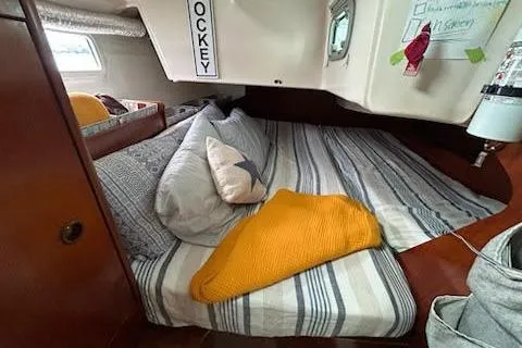 Slide: The Image of Cozy cabin interior of 1994 Beneteau Oceanis 351 sailboat with striped bedding. - 28