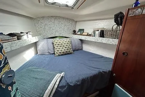 Slide: The Image of Cozy cabin interior of 1994 Beneteau Oceanis 351 sailboat with bed and storage shelves. - 29
