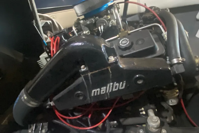 Slide: The Image of 1998 Malibu Sportster engine with red wiring and black components. - 10