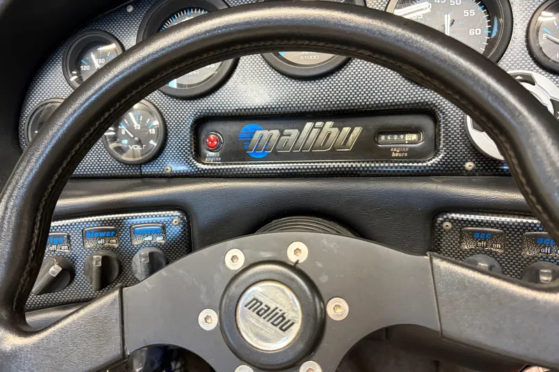 Slide: The Image of Dashboard of a 1998 Malibu Sportster boat with gauges and steering wheel. - 4