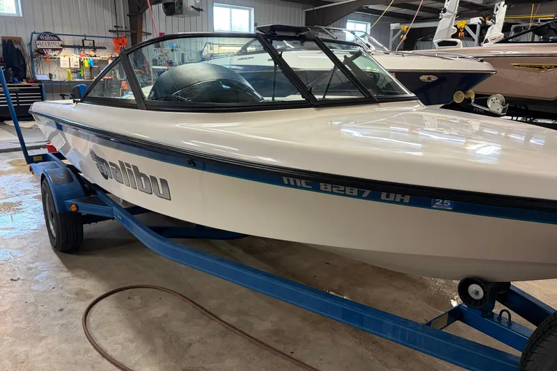 Slide: The Image of 1998 Malibu Sportster boat on trailer in garage setting. - 6