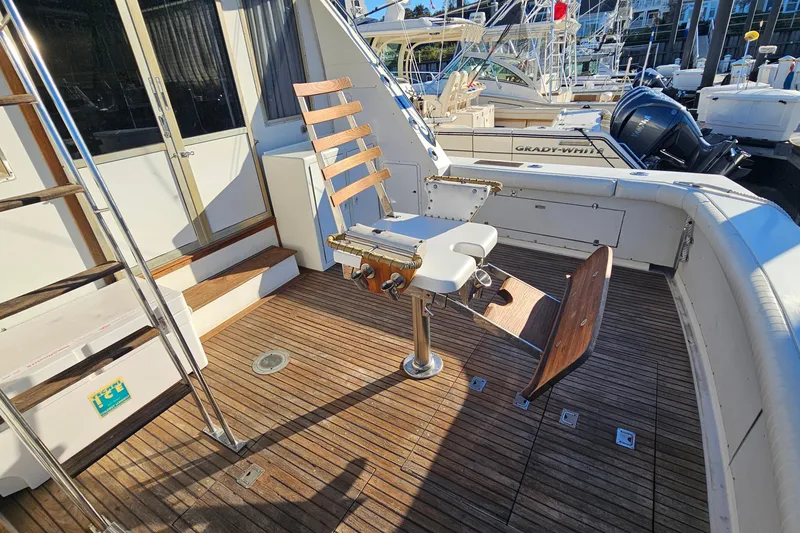 Slide: The Image of 1980 Bertram 42 Convertible yacht deck with fishing chair and wooden flooring. - 14
