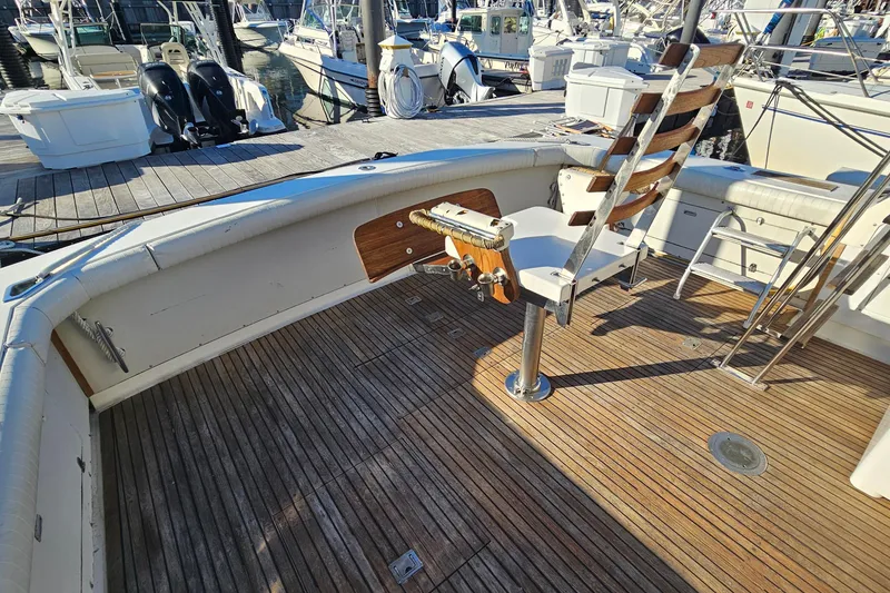Slide: The Image of 1980 Bertram 42 Convertible boat deck with wooden flooring and fishing chair. - 17