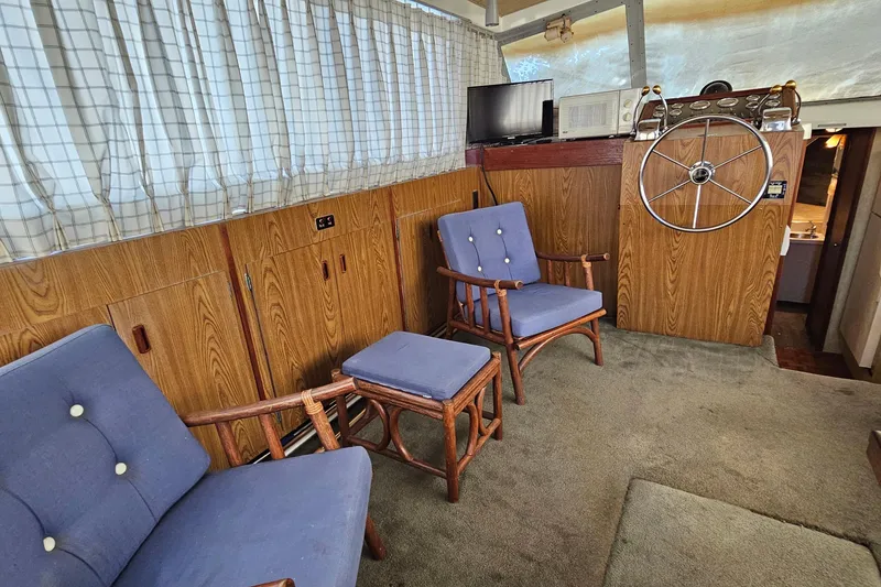 Slide: The Image of Interior of 1980 Bertram 42 Convertible with wooden paneling, blue chairs, and steering wheel. - 20