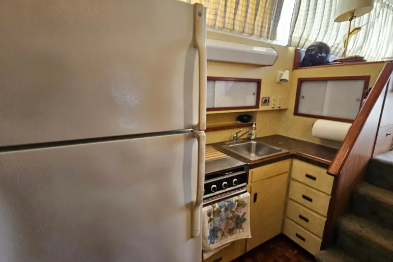 Slide: The Image of 1980 Bertram 42 Convertible yacht kitchen with fridge, stove, and sink. - 25