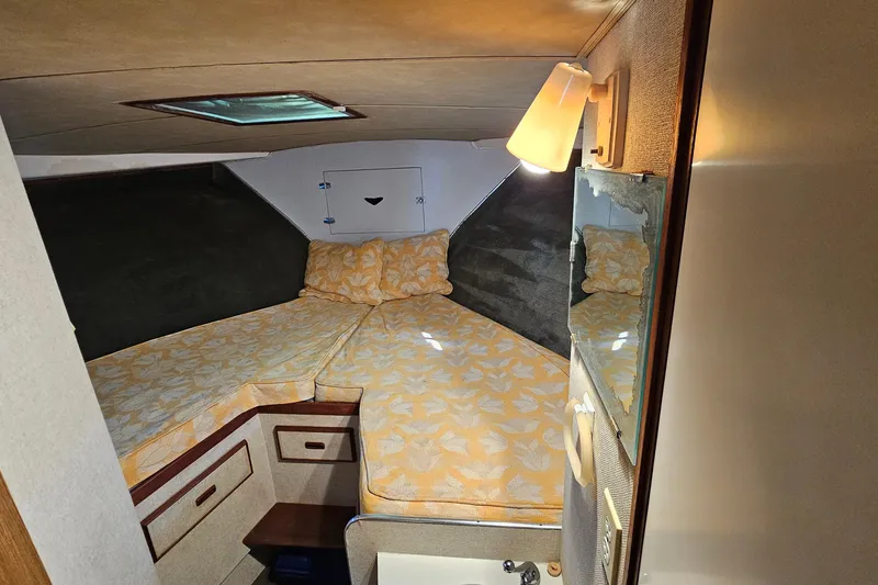 Slide: The Image of Cozy cabin interior of 1980 Bertram 42 Convertible with floral bedding and soft lighting. - 26