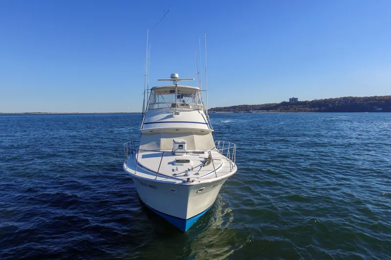 Slide: The Image of 1980 Bertram 42 Convertible yacht on open water under clear blue sky. - 3