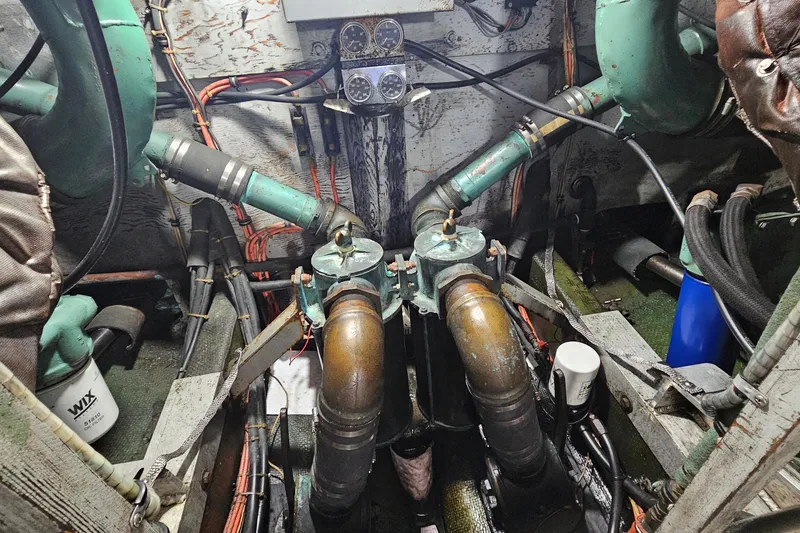 Slide: The Image of Engine room of a 1980 Bertram 42 Convertible with visible pipes and gauges. - 46