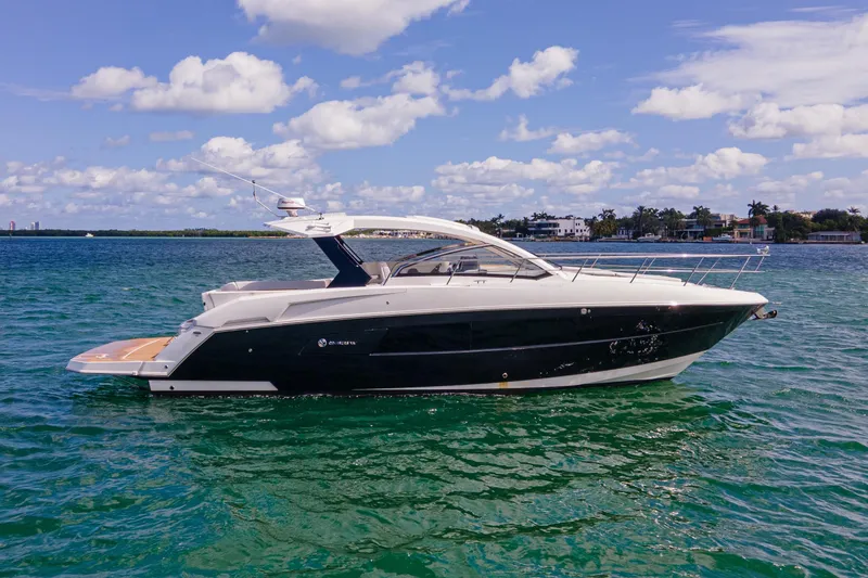 Slide: The Image of 2018 Cruisers Yachts 390 Express Coupe on open water with city skyline backdrop. - 3