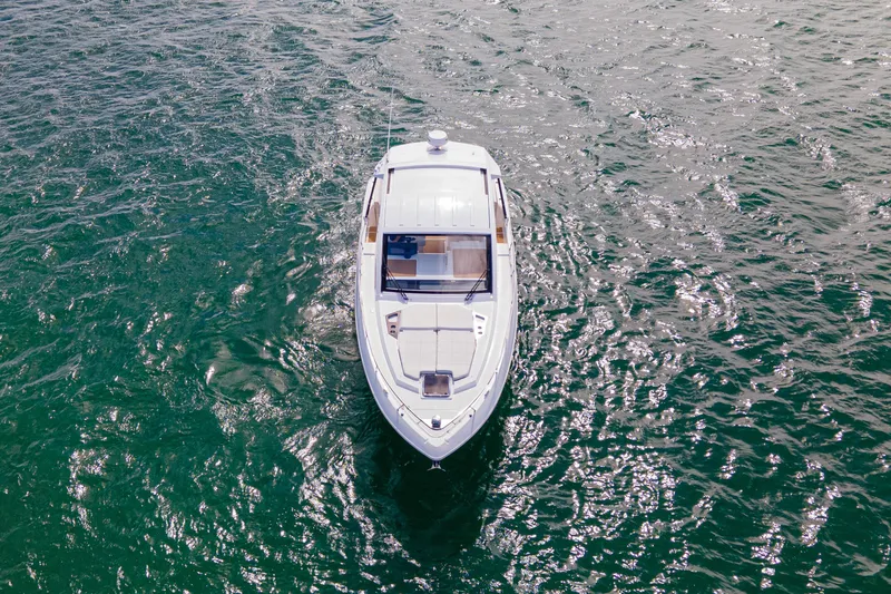 Slide: The Image of 2018 Cruisers Yachts 390 Express Coupe on open water under a partly cloudy sky. - 5