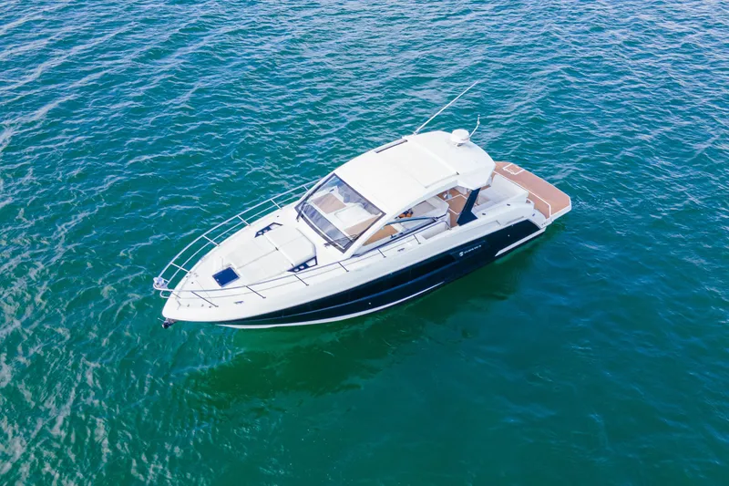 Slide: The Image of 2018 Cruisers Yachts 390 Express Coupe on clear blue water. - 13