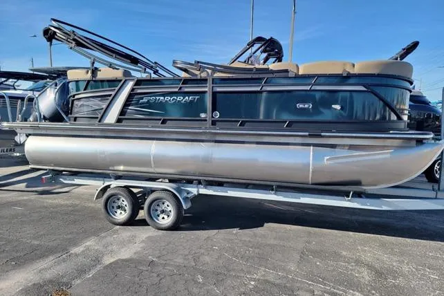 The Image of 2024 Starcraft SLS 1 pontoon boat on trailer, sleek design, outdoor display. - 0