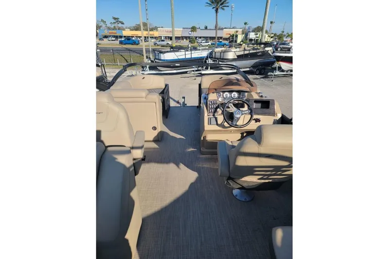 Slide: The Image of 2024 Starcraft SLS 1 boat interior with beige seating and modern dashboard controls. - 7