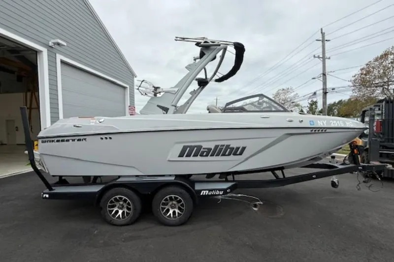 Slide: The Image of 2022 Malibu Wakesetter 22 LSV boat on trailer, parked outside a garage. - 3