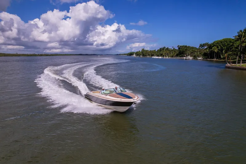 Slide: The Image of 2017 Chris-Craft Corsair 28 Heritage Edition cruising on a scenic waterway under blue skies. - 12