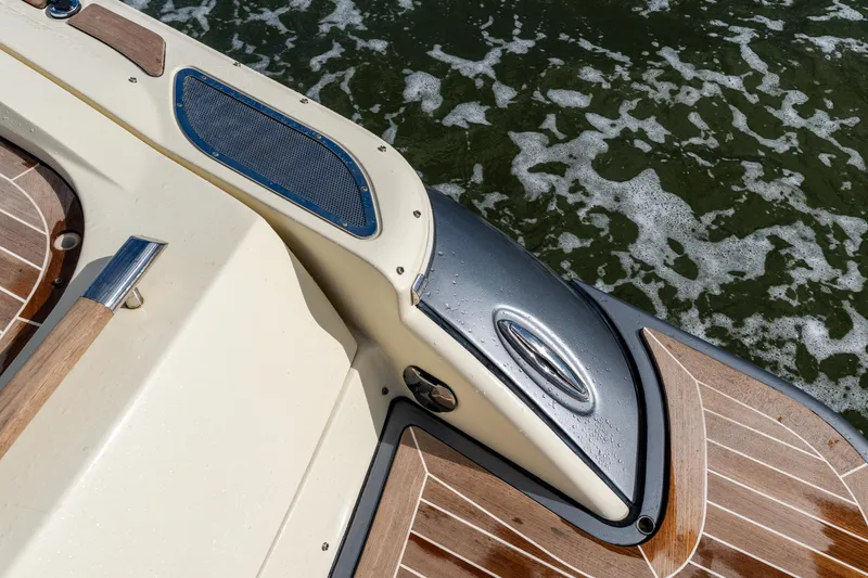 Slide: The Image of 2017 Chris-Craft Corsair 28 Heritage Edition boat detail with teak wood and water backdrop. - 18