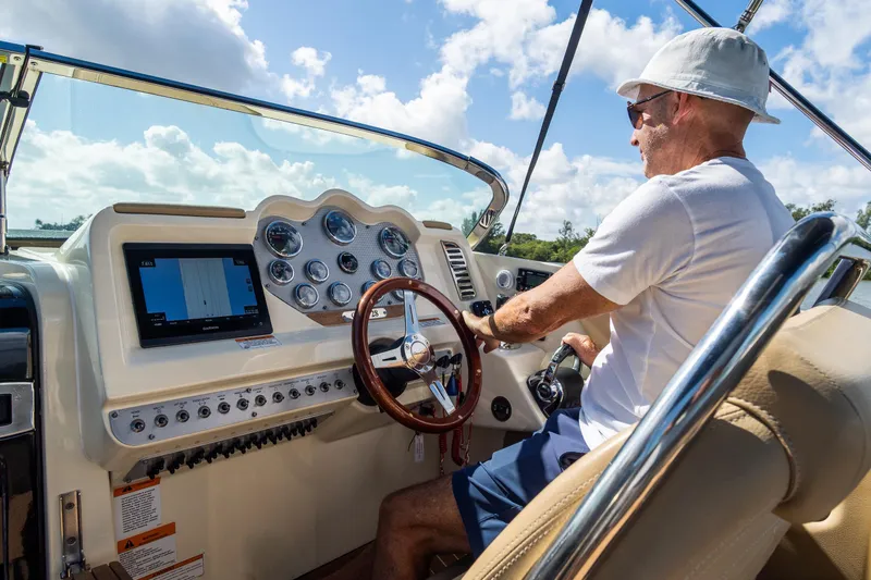 Slide: The Image of Man steering 2017 Chris-Craft Corsair 28 Heritage Edition boat under sunny skies. - 28