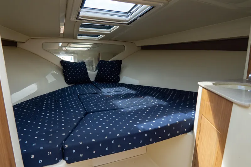 Slide: The Image of 2017 Chris-Craft Corsair 28 Heritage Edition cabin with blue patterned bedding. - 68