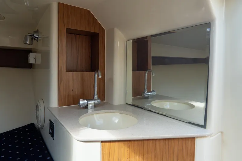 Slide: The Image of 2017 Chris-Craft Corsair 28 Heritage Edition bathroom with sink, mirror, and wood accents. - 70