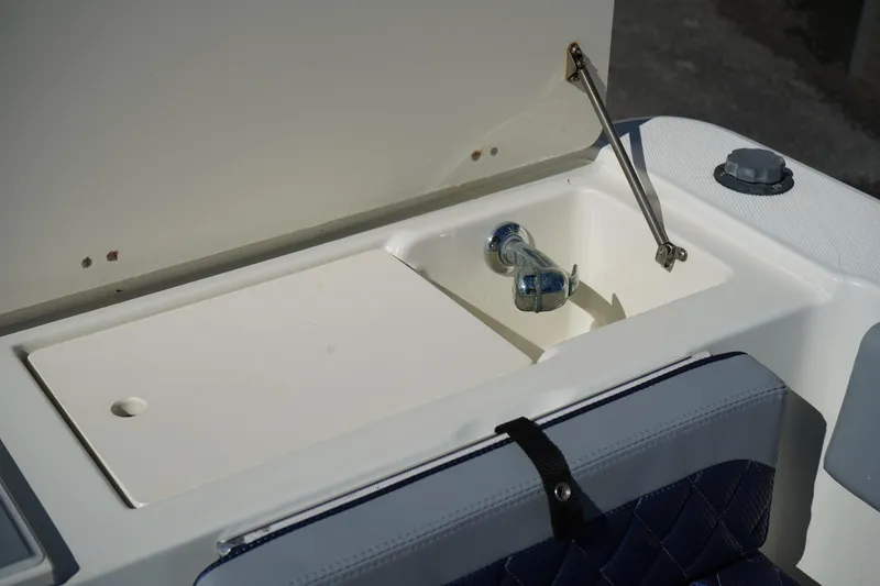 Slide: The Image of Fish Hawk 230 CC 2002 boat compartment with open lid and faucet. - 10
