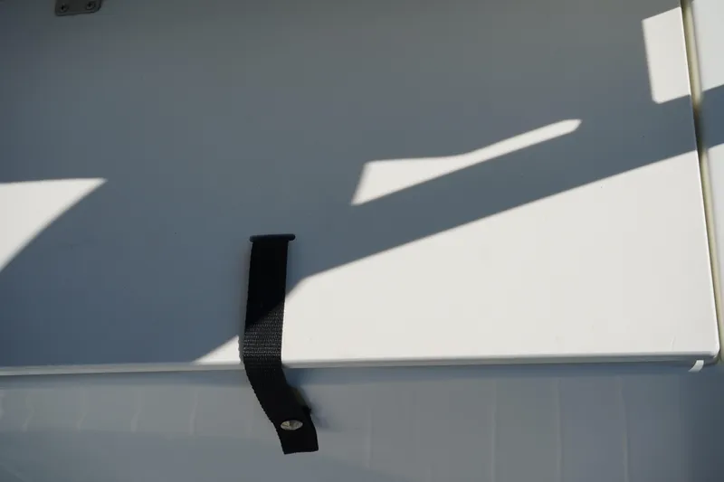 Slide: The Image of 2002 Fish Hawk 230 CC boat detail with strap and shadow on white surface. - 11