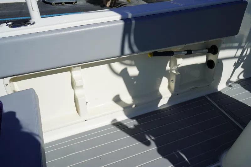 Slide: The Image of Interior view of a 2002 Fish Hawk 230 CC boat, featuring seating and storage compartments. - 13