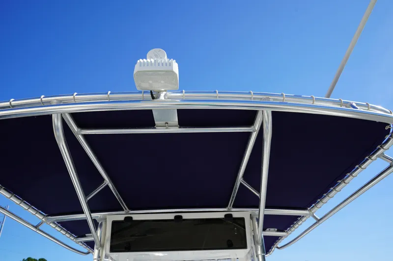 Slide: The Image of T-top of 2002 Fish Hawk 230 CC boat against clear blue sky. - 15