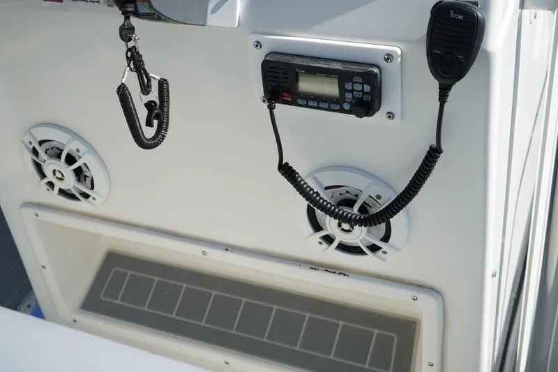 Slide: The Image of 2002 Fish Hawk 230 CC boat console with radio, speakers, and safety lanyard. - 18