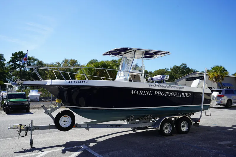Slide: The Image of 2002 Fish Hawk 230 CC boat on trailer, labeled "Marine Photographer," in parking lot. - 2
