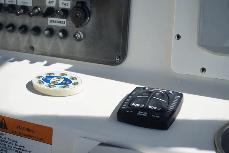 Slide: The Image of Control panel of a 2002 Fish Hawk 230 CC boat with trim tab controls. - 22