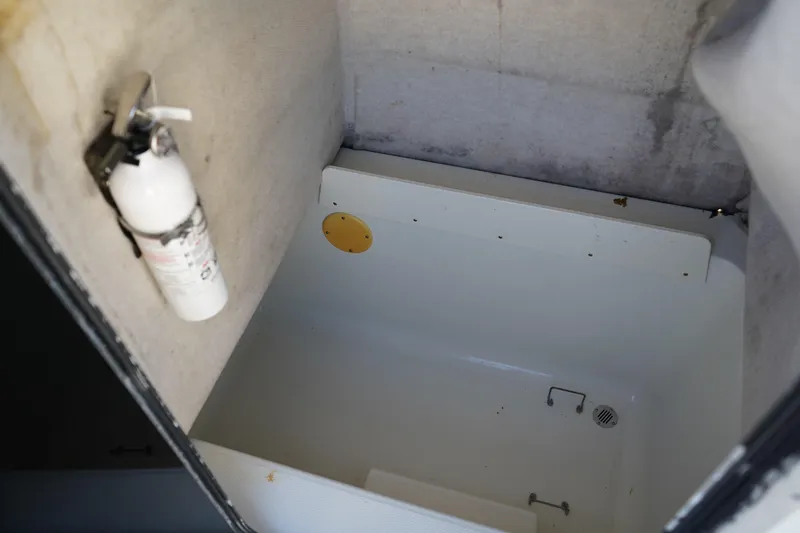 Slide: The Image of Interior of 2002 Fish Hawk 230 CC boat with fire extinguisher and storage compartment. - 27