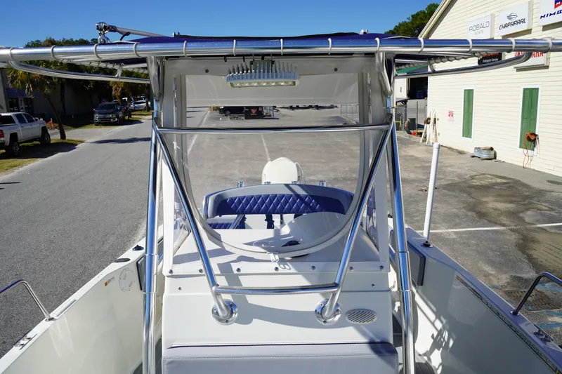 Slide: The Image of 2002 Fish Hawk 230 CC boat with T-top and blue seating, parked outdoors. - 28