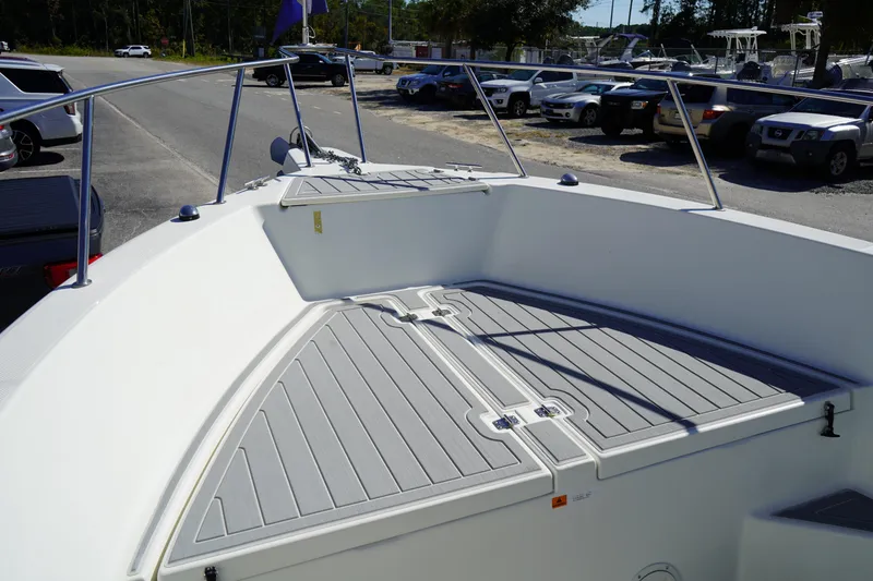 Slide: The Image of 2002 Fish Hawk 230 CC boat deck with storage compartments, parked in a lot. - 30