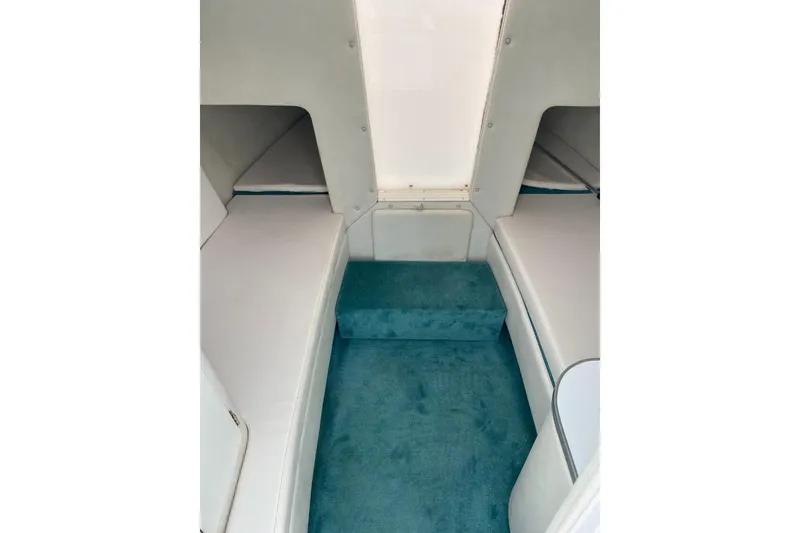 Slide: The Image of 2004 Envision 2900 Combo boat interior with white seating and teal carpet. - 11