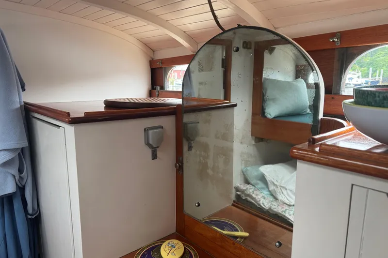 Slide: The Image of Interior of a 1940 Elco Cruisette boat with wooden cabinetry and cozy bedding. - 14